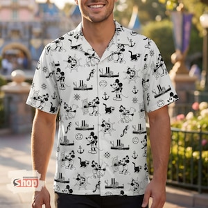 May include: White button-down shirt with a black Mickey Mouse pattern. The design includes Mickey Mouse illustrations, ships, anchors, and steering wheels. The shirt has short sleeves and a classic collar.