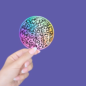 May include: A rainbow iridescent vinyl sticker of a volleyball with a leopard print design.