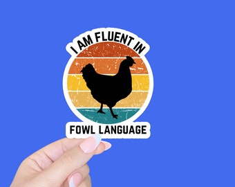 May include: A retro-style sticker with a chicken silhouette and the text "I am fluent in fowl language".
