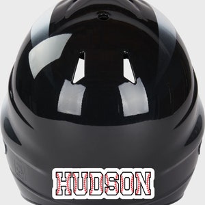 May include: Black baseball helmet with a white stripe and a red and white baseball stitch design nameplate that says "HUDSON".
