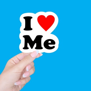 May include: A white sticker with the words "I love Me" in black text and a red heart.