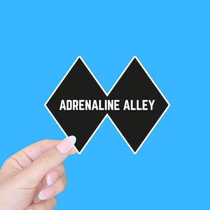 May include: A black and white sticker with the text "Adrenaline Alley" in a diamond shape.