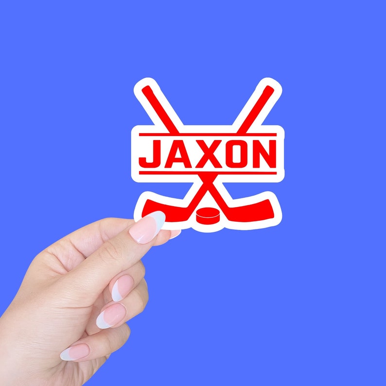 May include: White sticker with a red hockey stick design and the name "Jaxon" in red letters.