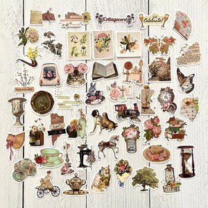 May include: A collection of vintage-style stickers featuring various images, including flowers, animals, books, teacups, and a train. The stickers are printed on white paper and have a distressed, aged look. The text "Cottagecore" and "Let's Celebrate!" are visible on two of the stickers.