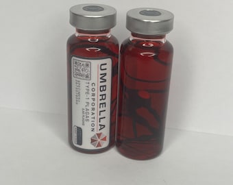 Peut inclure: Deux flacons en verre avec des bouchons argentés, remplis d'un liquide rouge et de motifs noirs en forme de veines. Un flacon porte l'inscription "UMBRELLA CORPORATION TYPE-1 PLAGAS". L'autre flacon n'est pas étiqueté.
