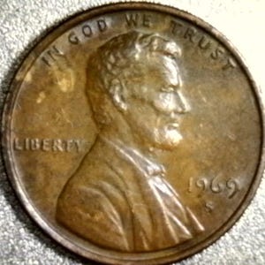 Op de afbeelding: Een close-up van een koperkleurige Lincoln penny uit 1969. De munt toont het profiel van Abraham Lincoln, de woorden "IN GOD WE TRUST" en "LIBERTY". Het jaartal "1969" is zichtbaar.