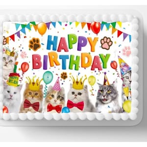 May include: A white cake with a colorful 'Happy Birthday' banner and six cats wearing party hats. The cake is decorated with confetti and balloons.