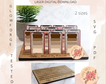 May include: Laser cut wooden display stand for earrings or cards. The stand is made of wood and has a natural finish. It features a rectangular base with slots for holding cards or earrings. The stand is labelled "Male it By Esmeralda".