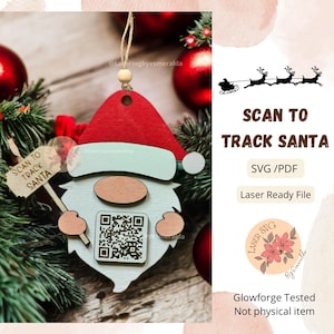 May include: A wooden Christmas ornament shaped like a Santa Claus gnome holding a sign that says "Scan to Track Santa". The ornament has a QR code on the front and is laser cut. The image also includes the text "Laser SVG" and "Glowforge Tested".