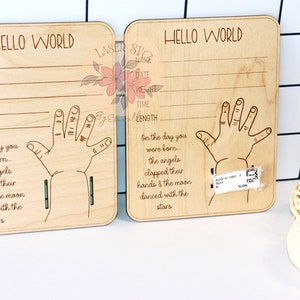 Pu&ograve; includere: Due targhe in legno con il testo "Hello World" inciso su di esse. Ogni targa ha uno spazio per il nome, la data, il peso, l'ora e la lunghezza di un bambino. Le targhe presentano anche un contorno di impronta di mano e una dolce poesia sugli angeli che battono le mani e la luna che balla con le stelle.