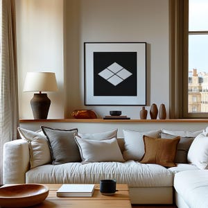 Puede incluir: Un salón con un sofá seccional color crema y cojines en tonos neutros. Una mesa de centro de madera con un libro y una taza negra. Una obra de arte geométrica en blanco y negro enmarcada cuelga sobre el sofá.
