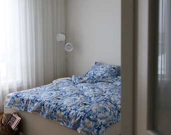 Set of three linens. duvet cover  and two pillowcases  for the bedroom. blue flowers appear in a print fabric pattern.