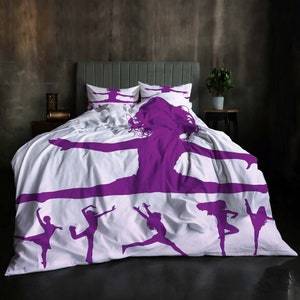 May include: White bedding with a purple silhouette of a dancer in a leaping pose. The bedding features a repeating pattern of smaller dancers in various poses.