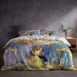 May include: A duvet cover and pillowcase set with a vibrant illustration of Belle and the Beast from Beauty and the Beast. The design features a blue and yellow colour scheme, depicting a romantic scene from the film.
