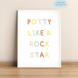 May include: A white framed print with the text "POTTY LIKE A ROCK STAR" in colorful letters. The letters are in different colors, including yellow, orange, blue, and pink.