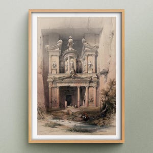 Könnte beinhalten: Gerahmter Druck des Schatzhauses in Petra, Jordanien. Das Kunstwerk zeigt die antike architektonische Fassade, die in Sandsteinfelsen gemeißelt wurde. Der Druck hat einen hellbraunen Holzrahmen und einen Aquarellstil.