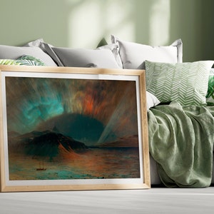 Può includere: Una stampa artistica incorniciata raffigurante un paesaggio con un'aurora boreale sopra un terreno montuoso. L'opera d'arte presenta vibranti tonalità di turchese, arancione e rosso, con una piccola barca sull'acqua. La cornice è di colore legno chiaro.