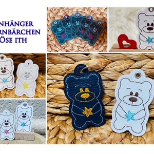 May include: A set of five embroidered felt bear keychains. The bears are holding a star and are in various colors, including blue, white, and black. The text "ANHÄNGER STERNBÄRCHEN ÖSE ITH" is visible in the top left corner of the image.