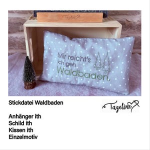 Könnte beinhalten: Ein graues Kissen mit weißen Punkten und grünem Sticktext, der "Mir reicht's Ich geh Waldbaden." lautet. Das Kissen liegt auf einer Holzoberfläche.