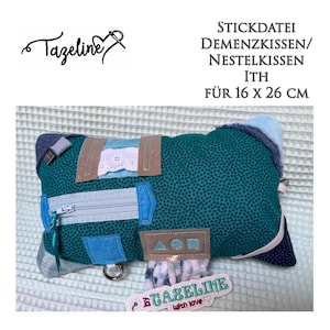 May include: A teal blue and white fabric pillow with a zipper, various fabric patches, and a tag that says "Gazeline with love". The pillow is 16 inches by 26 inches and is labelled as a "Dementia Pillow/Nestle Pillow".