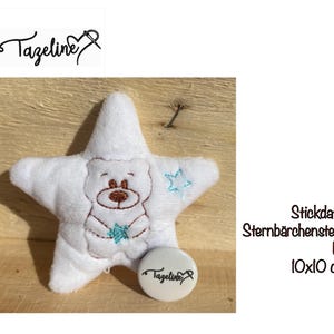 May include: White plush star with a brown bear embroidered on it holding a blue star. The star is 10 cm by 10 cm.