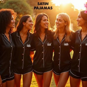 Peut inclure: Quatre femmes portant des pyjamas en satin noir avec des bordures blanches et du texte brodé. Le texte sur les pyjamas est "Chief Coach", "Bride Tribe" et "Bride Tribe".
