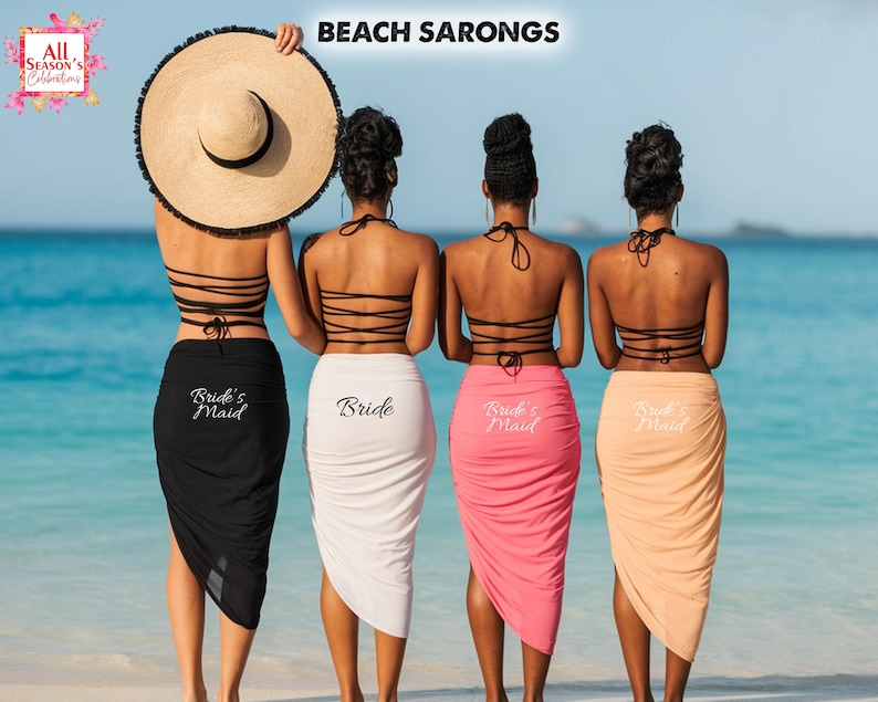 May include: Four women stand on a beach wearing matching sarongs and halter tops. The sarongs are black, white, pink, and peach, with "Bride's Maid" or "Bride" printed on them. One woman holds a large straw sun hat. The text "Beach Sarongs" is at the top.