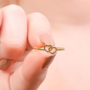 May include: A gold ring with two interlocking heart shapes.