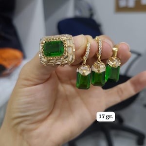 Puede incluir: Un anillo de oro y tres pendientes con piedras preciosas verde esmeralda y acentos de circonita cúbica transparentes. El conjunto de joyas pesa 17 gramos.