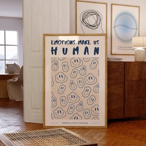 Może przedstawiać: Beżowy plakat z niebieskim tekstem, który brzmi "EMOTIONS MAKE US HUMAN" i wzorem niebieskich uśmiechniętych twarzy. Tekst na dole brzmi "embrace every emotion".