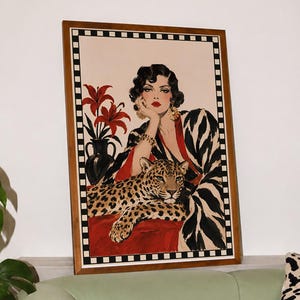 Puede incluir: Una impresión artística rectangular enmarcada que muestra la ilustración de una persona con cabello oscuro y labios rojos, vistiendo una bata con estampado blanco y negro, apoyando la mano sobre un leopardo, con lirios rojos en un jarrón negro.