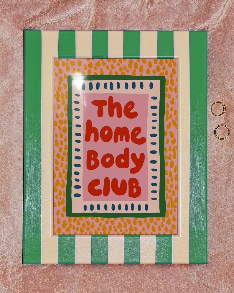 Playful typography poster featuring the phrase The Home Body Club in bold red lettering on a soft pink background. Framed with green and cream borders and surrounded by mustard yellow abstract dots, this colorful maximalist design blends cozy lifestyle humor with eclectic pattern layering and retro-inspired charm.Home Body Poster, Typography Wall Art, Cozy Quote Print, Maximalist Decor, Eclectic Print, Retro Style Poster, Entryway Wall Decor, Bold Letter Art, Trendy Art Print, Dopamine Color Art