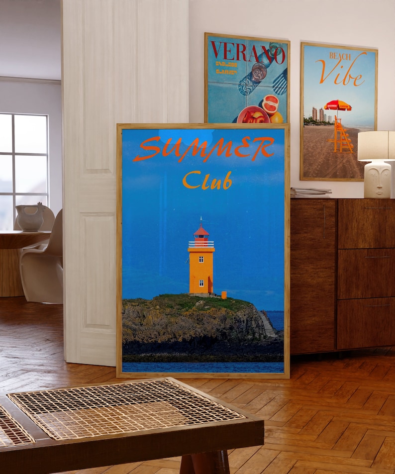 May include: A framed poster with a blue background and a lighthouse on a rocky island. The poster has the text "Summer Club" in orange and red letters.
