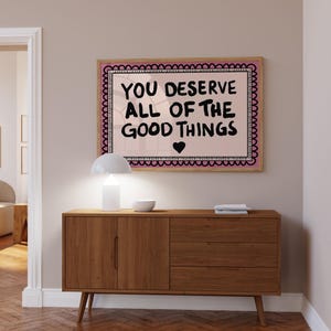A heartwarming affirmation poster featuring the phrase You Deserve All Of The Good Things in hand-lettered black text with a pink and cream border. Perfect for self-love decor, home offices, or as a thoughtful gift. This piece adds positivity, encouragement, and warmth to any wall.You Deserve Poster, Self Love Wall Art, Positive Quote Print, Motivational Home Art, Pink Modern Poster, Inspirational Typography, Empowering Print, Daily Affirmation Art, Encouraging Quote, Feminine Room Print