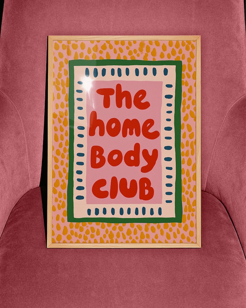 Playful typography poster featuring the phrase The Home Body Club in bold red lettering on a soft pink background. Framed with green and cream borders and surrounded by mustard yellow abstract dots, this colorful maximalist design blends cozy lifestyle humor with eclectic pattern layering and retro-inspired charm.Home Body Poster, Typography Wall Art, Cozy Quote Print, Maximalist Decor, Eclectic Print, Retro Style Poster, Entryway Wall Decor, Bold Letter Art, Trendy Art Print, Dopamine Color Art