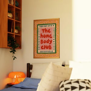 Playful typography poster featuring the phrase The Home Body Club in bold red lettering on a soft pink background. Framed with green and cream borders and surrounded by mustard yellow abstract dots, this colorful maximalist design blends cozy lifestyle humor with eclectic pattern layering and retro-inspired charm.Home Body Poster, Typography Wall Art, Cozy Quote Print, Maximalist Decor, Eclectic Print, Retro Style Poster, Entryway Wall Decor, Bold Letter Art, Trendy Art Print, Dopamine Color Art