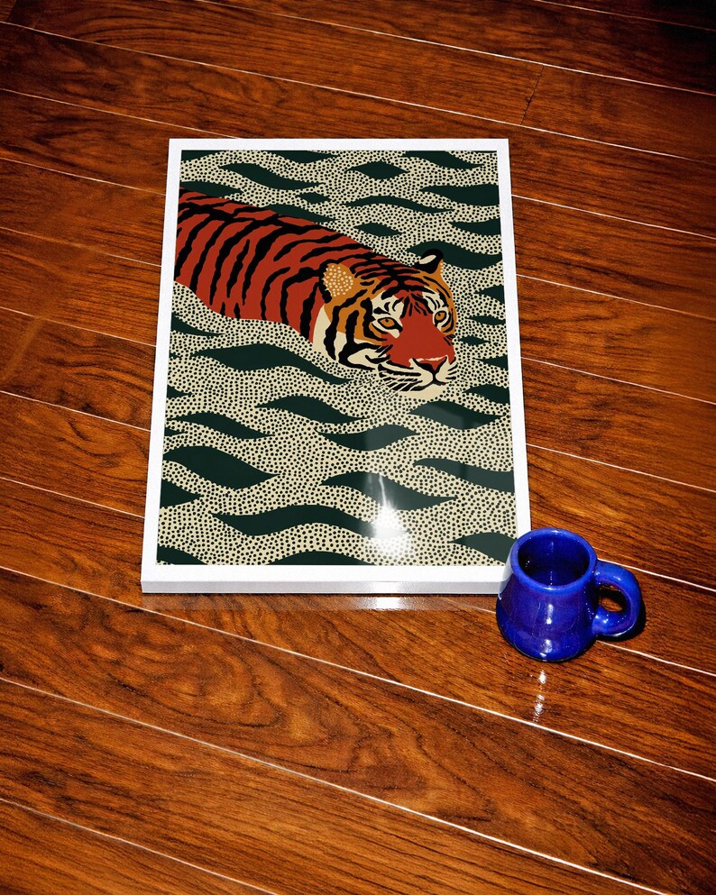 Stylized tiger illustration moving through abstract green wave patterns with dotted textures on a neutral background. The bold orange and black striped tiger contrasts with the rhythmic organic shapes, creating a dynamic maximalist composition. Hand drawn details and modern folk art influences give the artwork a playful yet powerful visual identity. Perfect for living room wall decor, kids room styling, eclectic interiors, or jungle themed spaces seeking a bold statement animal artwork.