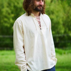 Op de afbeelding: Een wit overhemd met lange mouwen en een vetersluiting. Het shirt is gemaakt van een zachte, natuurlijke stof en heeft een ontspannen pasvorm.