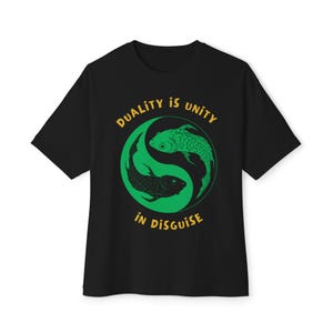 May include: Black t-shirt with a green and black fish design inside a green yin-yang symbol. The text "DUALITY IS UNITY IN DISGUISE" is printed in yellow above and below the symbol. The shirt has a crew neck and short sleeves.