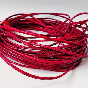 May include: A spool of bright pink leather cord with a snakeskin pattern. The cord is coiled and ready to be used for crafting projects.