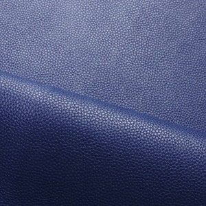以下が含まれることがあります： 質感のある青い革の生地のクローズアップ。革は粒状の表面と濃い青色をしています。