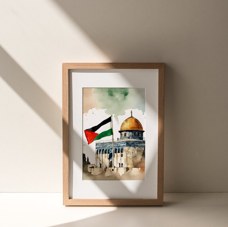 May include: A framed watercolor painting of the Dome of the Rock in Jerusalem, with a Palestinian flag waving in the wind. The painting is set against a light blue sky with white clouds.