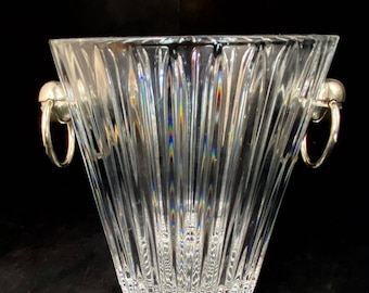 May include: A clear glass ice bucket with a fluted design and silver metal handles.