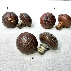 May include: Four antique door knobs with intricate designs. The knobs are made of brass and have a dark brown patina. The knobs are numbered 1, 2, and 3.
