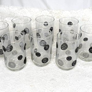 May include: Set of eight clear glass tumblers with black and white coin designs.