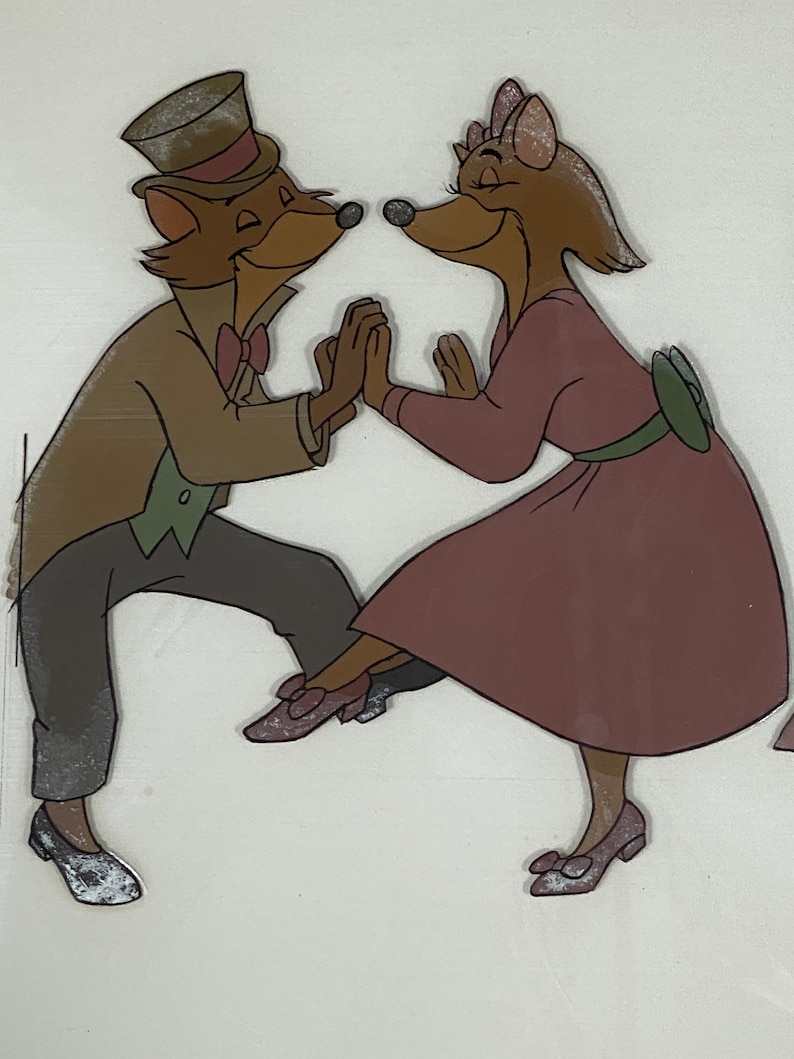 Pu&ograve; includere: Illustrazione animata di due volpi antropomorfe che ballano. La volpe maschio indossa un abito marrone, un cappello a cilindro e un papillon. La volpe femmina indossa un vestito malva con una cintura e un fiocco verdi. Si tengono per mano e sorridono.