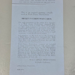 Pu&ograve; includere: Un foglio di carta bianco con testo su Mickey's Christmas Carol di Walt Disney Productions. Il testo descrive il processo di animazione, inclusi i dipinti su celluloide e il loro ruolo nella creazione dell'illusione del movimento.