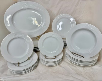 Può includere: Un set di stoviglie in porcellana bianca con un design a spirale decorativo. Il set comprende un grande piatto ovale, una zuppiera, un piatto da portata e un piatto da insalata.