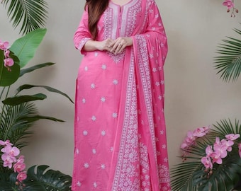 Puede incluir: Un conjunto étnico de tres piezas en color rosa brillante que incluye un kurta recto de manga larga con bordados florales blancos, pantalones rectos a juego y un dupatta con un borde blanco intrincado y motivos florales.