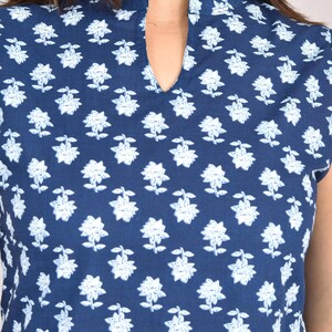 Puede incluir: Una blusa azul marino con un estampado floral blanco. La blusa presenta un cuello mandar&iacute;n y un escote de ojo de cerradura. La prenda de manga corta est&aacute; hecha de una tela suave y ligera, perfecta para el clima c&aacute;lido.